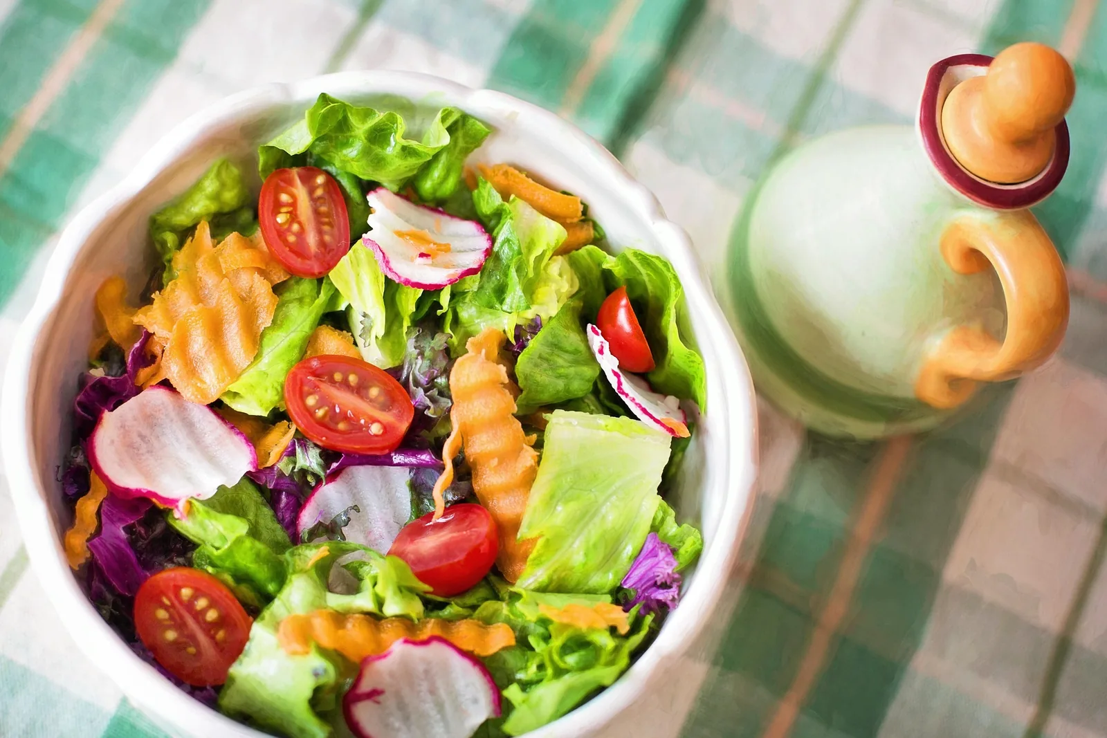 Ensalada fresca con lechuga, tomate, zanahoria y rabanitos sobre una mesa